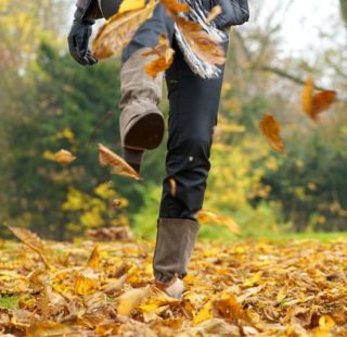 Woman kicking up Autumn leaves in a pair of boots